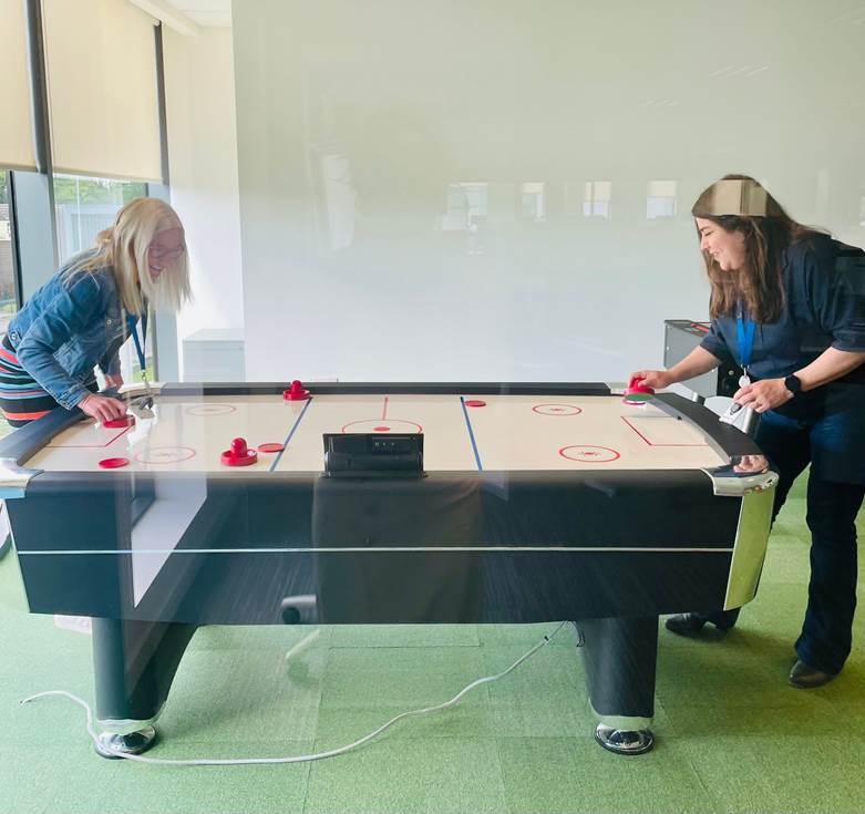 Employees enjoying a game of air hockey at the Cork office.