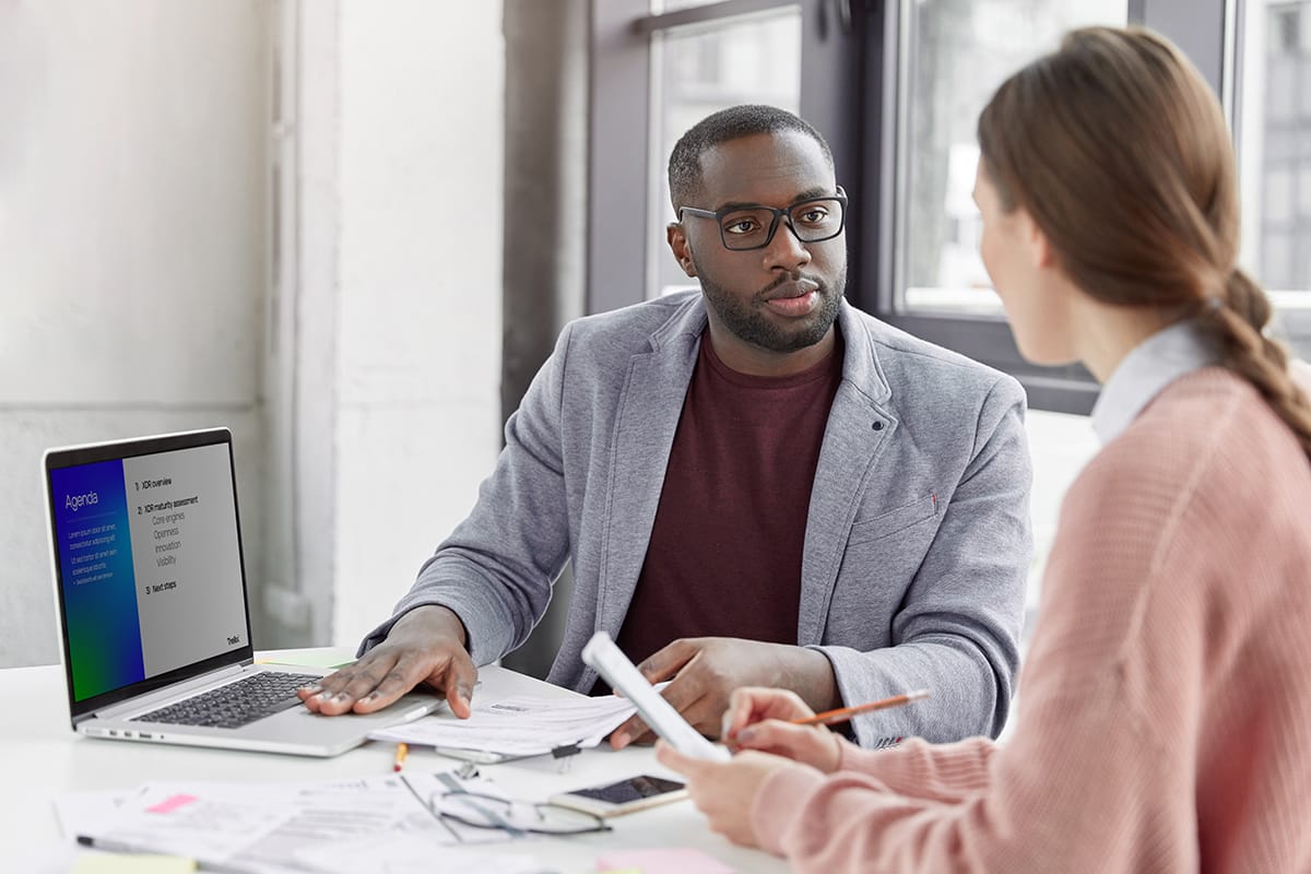 2 professionals discussing options in an office