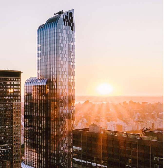 Skyscraper in a city with a sunrise in the background